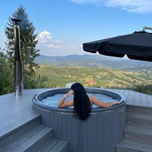 a woman in a hot tub on a deck at Rest Hub in Slavske