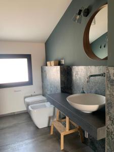 a bathroom with a sink and a toilet and a mirror at PetraSicula Apartment in Acitrezza