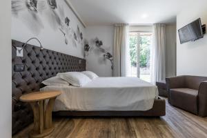 a bedroom with a bed and a couch and a table at Azienda Agrituristica Calronche in Refrontolo