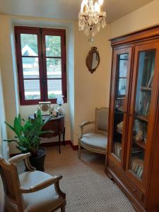 a living room with a chandelier and a table and chair at TY KOANT in Daoulas