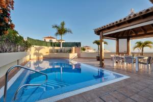 - une piscine sur une terrasse avec une table et des chaises dans l'établissement Villa Happy Holidays Pool Private, à Puerto de Santiago