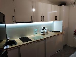 a kitchen with white cabinets and a counter top at theApartments Manufaktura in Łódź