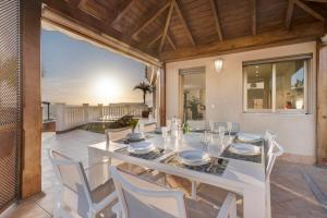 une salle à manger avec une table et des chaises blanches dans l'établissement Villa Happy Holidays Pool Private, à Puerto de Santiago
