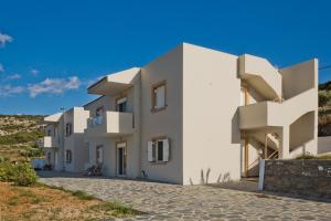 a row of white apartment buildings on a hill at Karpathos City View Apartments in Karpathos