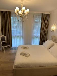 ein Schlafzimmer mit einem großen Bett mit zwei Handtüchern darauf in der Unterkunft BIRUTE AVENUE 2 BEDROOMS in Palanga + 10 Fotos