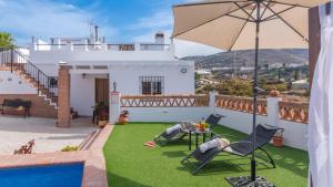 a house with a yard with a pool and an umbrella at Villa Naiara Torrox by Ruralidays in Torrox
