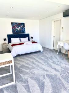 a bedroom with a large bed and a desk at Private Pool! Bantry Bay Large Flat with Solar in Cape Town