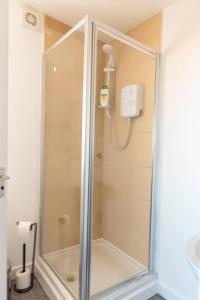 y baño con ducha y puerta de cristal. en Entire House with 3 Rooms en Liverpool