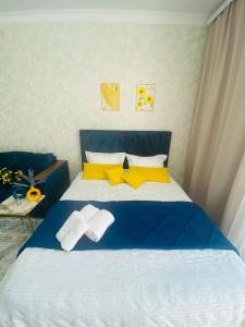 a bedroom with a blue and yellow bed with towels at Гранд Чемпион in Astana