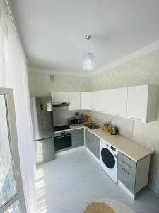 a kitchen with white cabinets and a counter top at Гранд Чемпион in Astana