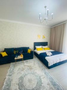 a bedroom with two beds and a blue couch at Гранд Чемпион in Astana
