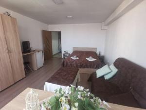 ein Hotelzimmer mit 2 Betten und einem Sofa in der Unterkunft Very good location in Hunedoara