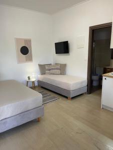 a bedroom with two beds and a tv on the wall at Katerina Sea Apartments in Kato Daratso