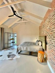 a bedroom with a bed and a brick wall at LTB - Kalm Riverside Living in Malgas