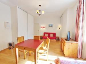 sala de estar con mesa y sofá rojo en Frimousse, Studio, wifi, centre Luchon, casier à skis, 3 personnes, en Luchon