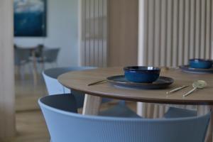 a wooden table with two blue cups and blue chairs at VANDUO Anykščiuose in Anykščiai
