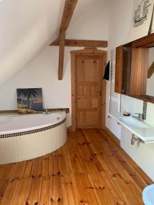 uma casa de banho com banheira e piso em madeira em Pod Lipami em Zawady