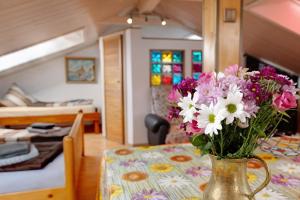 eine Vase mit Blumen auf einem Tisch in einem Zimmer in der Unterkunft Haus Schwanenweg in Konstanz