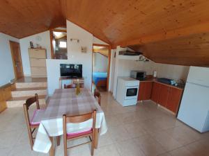 una cucina e una sala da pranzo con tavolo e sedie di Dario studio apartman a Kukljica (Cuclizza)