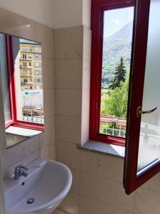 La salle de bains est pourvue d'un lavabo et d'une fenêtre avec vue. dans l'établissement Liberty House, à Châtillon