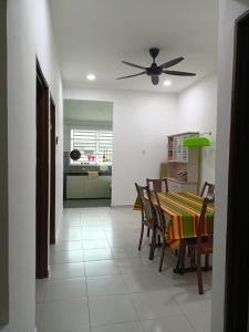 a dining room and kitchen with a table and chairs at Yasmeen Homestay Kijal Nenas 2 in Kijal