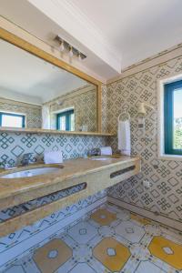 un bagno con due lavandini e un grande specchio di Vila Limão a Boliqueime