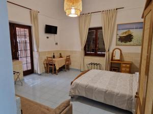 1 dormitorio con cama, mesa y comedor en Angolo di Paradiso en Favignana