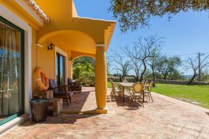 een patio met stoelen en tafels op een huis bij Vila Limão in Boliqueime