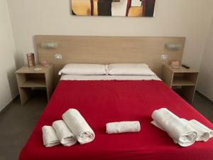 1 cama con 2 toallas en una manta roja en Palazzo 41 Rental Rooms, en San Pietro Vernotico