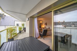 a balcony with a table and a dining room at L'Audacieux - Appt neuf avec vue sur les toits in Vannes