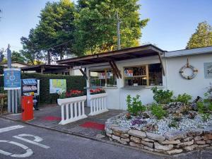 a white building with a flower garden in front of it at Camping Ancora in Comacchio