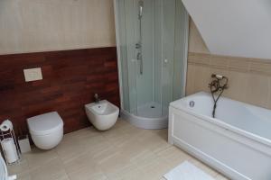 a bathroom with a tub and a toilet and a shower at Apartament FORREST w Rewie in Rewa