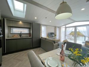 a kitchen and dining room with a table and chairs at Beautiful Luxury Lakeside Lodge Hot Tub Views Pass the Keys in Annan