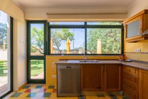 een keuken met een spoelbak en een raam bij Vila Limão in Boliqueime