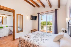 a bedroom with a bed and a bathroom with a window at Villa Paula in Son Carrio