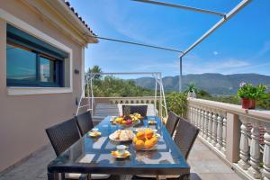 a table with bowls of fruit on a balcony at Zante Sunset Vibes Luxury Villa in Áno Yerakaríon