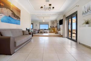 a living room with a couch and a table at Zante Sunset Vibes Luxury Villa in Áno Yerakaríon