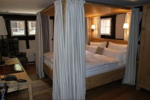 ein Schlafzimmer mit einem großen Bett mit Baldachin in der Unterkunft Maiensässhotel Guarda Val in Lenzerheide