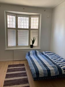 um quarto com uma cama num quarto com janelas em Corner apartment em Helsínquia