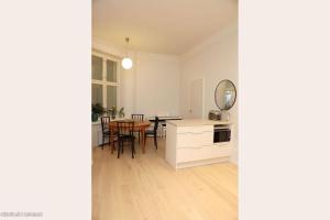 uma cozinha e sala de jantar com uma mesa e um espelho em Corner apartment em Helsínquia