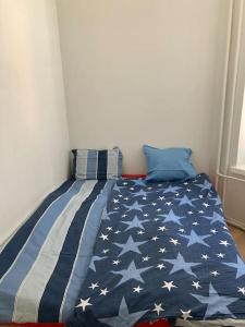 Uma cama com um cobertor de bandeira americana. em Corner apartment em Helsínquia
