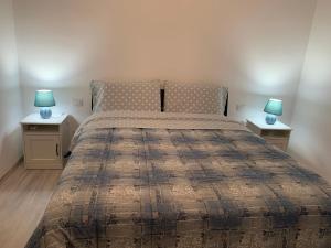 een slaapkamer met een groot bed met 2 nachtkastjes bij La Fortuna in Quiliano