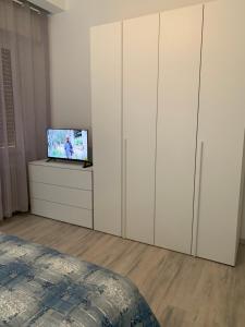 a bedroom with white cabinets and a tv on a dresser at La Fortuna in Quiliano