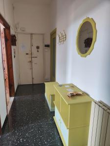 Habitación con armarios amarillos y espejo en la pared. en Appartamento Case Rosse, en Le Grazie