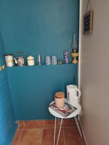 Una pequeña mesa en una habitación con una pared azul en La Vicoise Accueillante en Vic-Fezensac