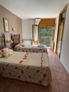 een slaapkamer met 2 bedden en een raam bij HOSTAL JJ salduero in Salduero