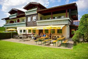 Menschen, die vor einem Gebäude an Tischen sitzen in der Unterkunft Ferienhotel Starennest in Schindelberg