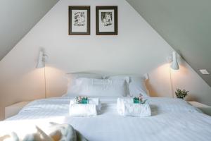 um quarto com uma cama branca com duas toalhas em Bonrepo Room 105 em Bruges