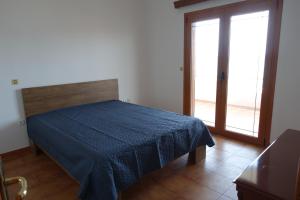 a bedroom with a bed with a blue blanket at Villa in Kalloni direkt am Meer, tolle Aussicht in Kalloni