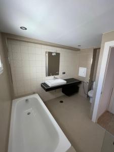 a bathroom with a tub and a sink and a toilet at MyHouseSpain - Ático con terraza en la playa in Gijón